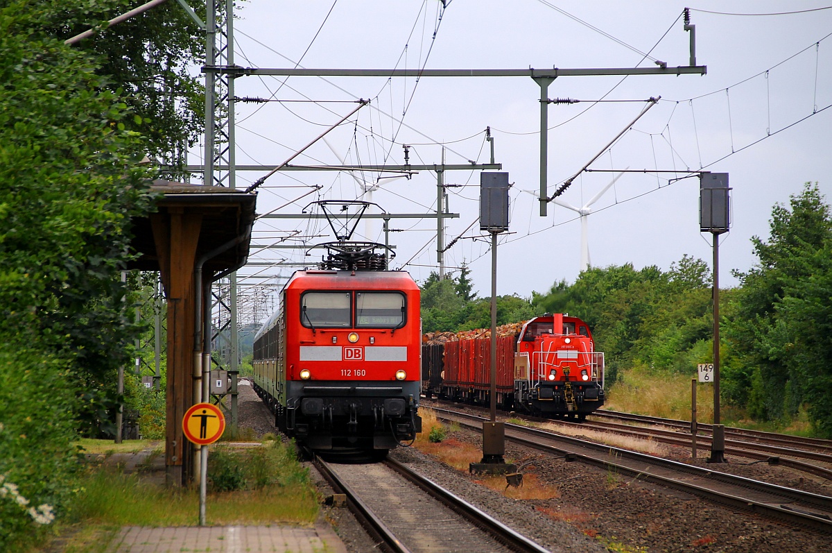 DB 112 160 mit SH-Express nach Hamburg kommt mit hohem Tempo von Flensburg durch Jübek gefahren während 261 098-8 mit ihrem Holzzug(EK 53566)im Gleis 3 warten muss. Jübek 19.06.2014
