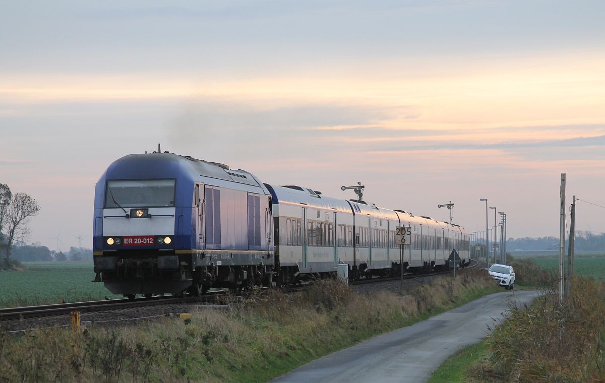 Die blaue BRLL ER 20-012 mit MP Garnitur als RE 6 nach Westerland/Sylt, hier bei der Ausfahrt aus dem Kreuzungsbahnhof Lehnshallig, 30.10.2021