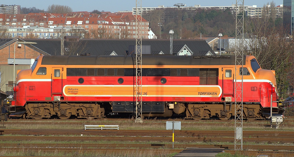 Gebaut unter der Seriennummer 2465 wurde die MX 1025 1993 nach 32 Betriebsjahren bei der DSB ausgemustert, sie bekam den rot/orangen Anstrich und war seitdem bei mind. zwei dänischen Privatbahnen als MX 26 im Einsatz, heute gehört sie den Midtjyske Jernbanen(MJ) und trägt den Namen  Torfisken . Aufgenommen in Aarhus am 20.11.2009