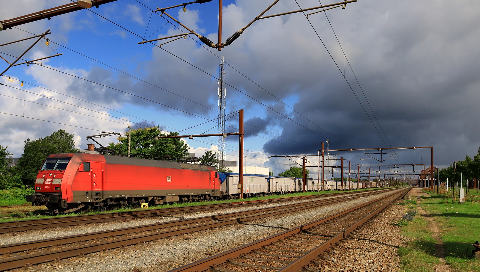 DBCSC Litra EG 3111 (91 86 010 3111-8 DK-DBCSC, REV/Cph/21.06.16, Verl/Cph/26.08.23) mit kurzem Güterzug und bedrohlicher Regenwolke im Anmarsch. Pattburg 22.07.2023