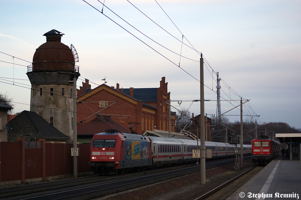 101 037-0  Klagenfurt Touristik  mit dem IC 142 von Berlin Ostbahnhof nach Schiphol (Airport) in Rathenow. Im Bahnhof steht immer noch die 112 186 mit dem RE4 (RE 37331) nach Ludwigsfelde, weil sie warten noch auf die RB13 (RB 17963) aus Stendal. Die hatte eine Versptung von 20min gehabt. 31.12.2011