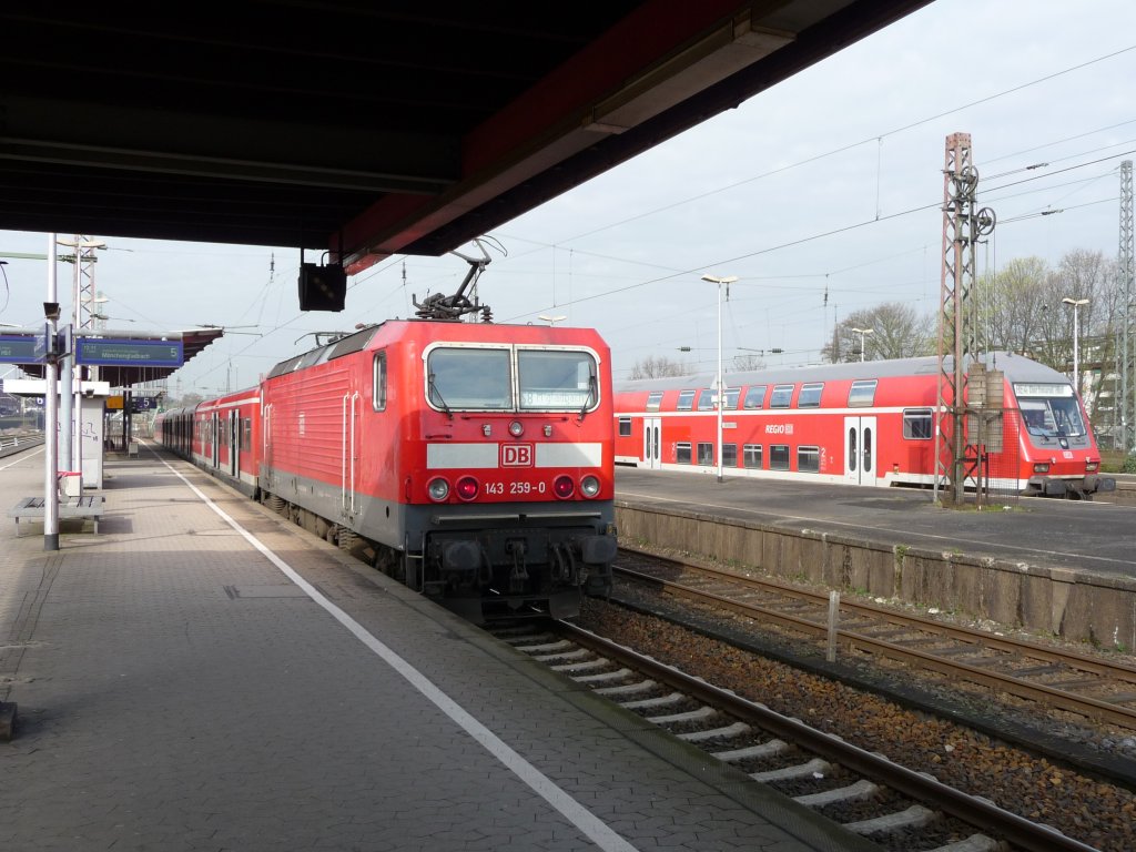 143 259 steht am 09.04.2010 in Wuppertal-Oberbarmen mit ihrer S-Bahn in Richtung Mnchengladbach bereit. Rechts ist eine DOSTO-Garnitur als RE4 nach Aachen zum Stehen gekommen. S8 -> Mnchengladbach Hauptbahnhof