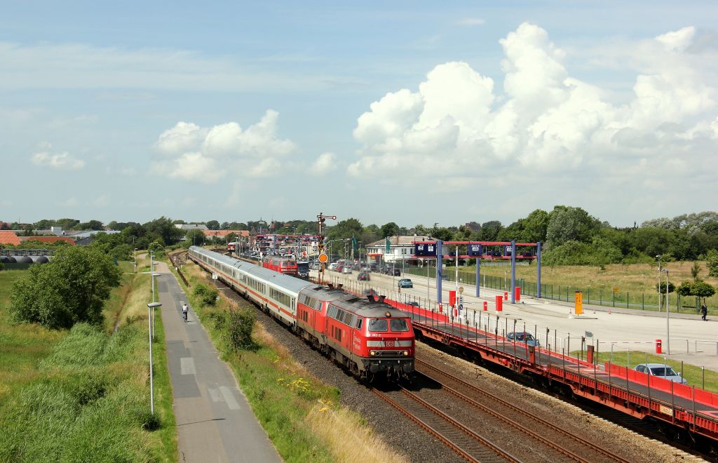 218 362-2 dieselte mit einer Schwesterlok und dem Intercity 2315 nach Frankfurt am Main am Haken am DB Autozug Terminal in Niebll vorbei.
