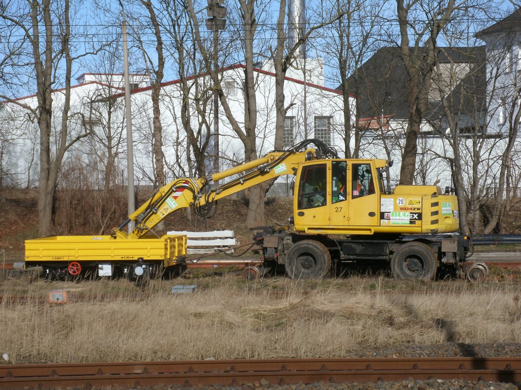 Am 03.Mrz 2012 stand dieser Zweiwegebagger mit einem Skl-Anhnger auf dem Ladegleis in Bergen/Rgen.