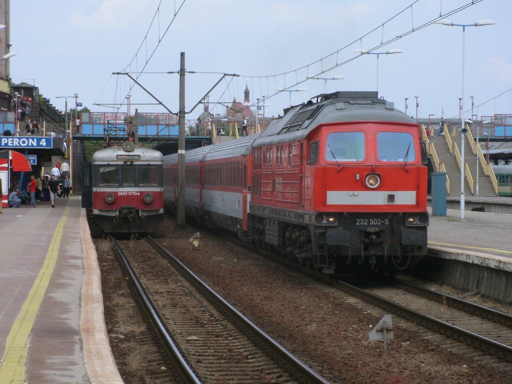 Auch das ist ein Foto wert treffen von 232 502 und einem polnischen Triebwagen EN57-1775 am 14.Mai 2011 in Szczecin Glowny.