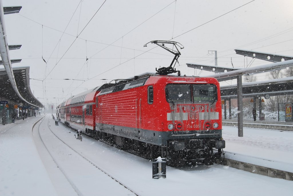 Auch ich schleiche mal auf Rostocker Hbf umher.Im dichten Schneetreiben des 03.12.2010 steht die 114 005 mit dem RE 5 nach Lutherstadt Wittenberg im oben genannten Hbf.