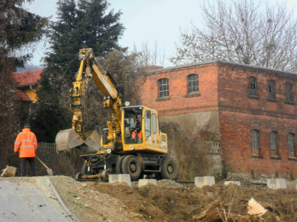 D neue Haltepunkt in Freyburg w�hrend der Bauphase. Laut Pressemitteilung vom 26.01.2012 wird der neue Hp nicht bis zum 31.01.2012 fertig werden. Hier sieht man einen Zweiwegebagger der Firma S�chsiche Bau GmbH bei dem Setzen der Bl�cke f�r den Bahnsteig; 26.01.2012