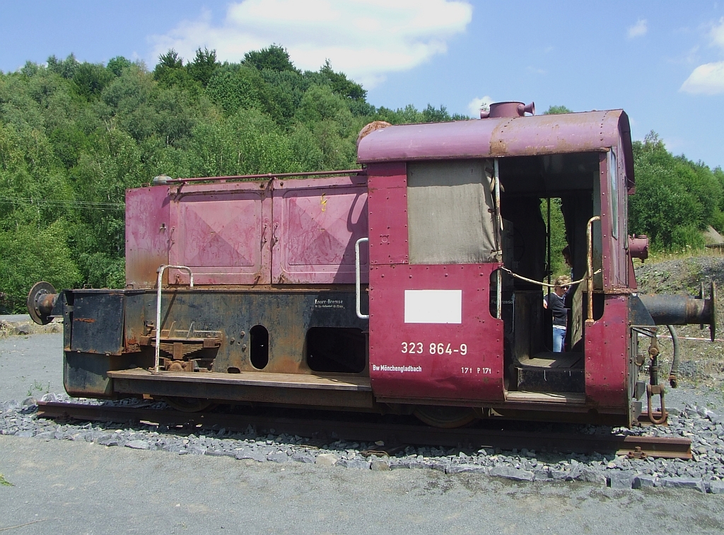 Denkmallok 323 864-9 (Köf II) im Stöffel-Park, Enspel/Ww am 18.07.2010. Die Lok wurde 1960 (Fabr.-Nr. 13232) bei der Firma Jung in Jungenthal bei Kirchen/Sieg gebaut und an die DB als  Köf 6794   ausgeliefert. 1968 erfolgte die Umzeichnung in  323 864-9 und nach der Endgültihgen Ausmusterung 1993 im BW Mönchengladbach an das Basaltwerk Jean Uhrmacher GmbH & Co. KG, Enspel (Westerwald) verkauft. Am 07.06.2010 erfolgte die Aufstellung als Denkmal.