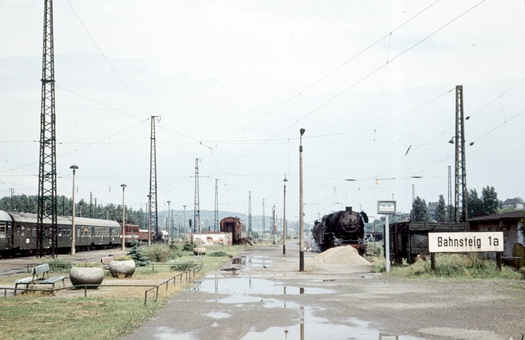 Der Bahnsteig 1a am 22.06.1980 in Naumburg Hbf. Das Bild zeigt gleich mehrere Rarit�ten, wie den alten Speisewagen der als Pausenversorgung der Bahnmitarbeiter diente. Au�erdem die DR 44 0389-5 als Heizlok f�r die Molkerei Naumburg und die Parteitagsbemalung. Der Bahnsteig 1a hie� betrieblich Gleis 24 und wurde dann durch sp�tere Umbauten als Gleis 22 bezeichnet. Fr�her sollen wohl dort Z�ge im Leunaverkehr abgefahren sein, daher im Volksmund auch der Ausdruck  Leunabahnsteig . Es gab jede Nacht eine Abstellung eines Leerpersonenzuges, der aus Gro�heringen auf Gleis 1 ankam.
Die Lok fuhr dann Lz nach Wei�enfels und die Wagen wurden mit einer Rangierlok wieder als Leerzug nach Gro�heringen bereit gestellt.
Weiterhin wurde das Gleis bei Bauarbeiten f�r in Naumburg beginnende Personenz�ge Richtung Wei�enfels genutzt. Manches Lokpersonal fuhr auch mit ihrer Lok gern bis zum Prellbock, weil sie dann sozusagen bis in die Kantine fahren konnten. (Foto: Klaus Pollm�cher, Text: Thomas Menzel)
