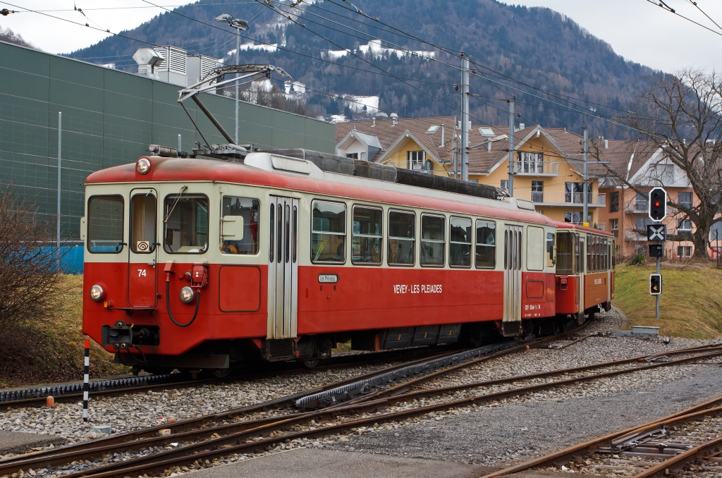 Der Gepcktriebwagen BDeh 2/4 Nr. 74 mit Steuerwagen Bt 221 der MVR (Transports Montreux–Vevey–Riviera) ex CEV (Chemins de fer lectriques Veveysans) kommt am  26.02.2012  vom Les Pliades (1.360 m . M.) hinab und fhrt in den Bahnhof Blonay ein. 