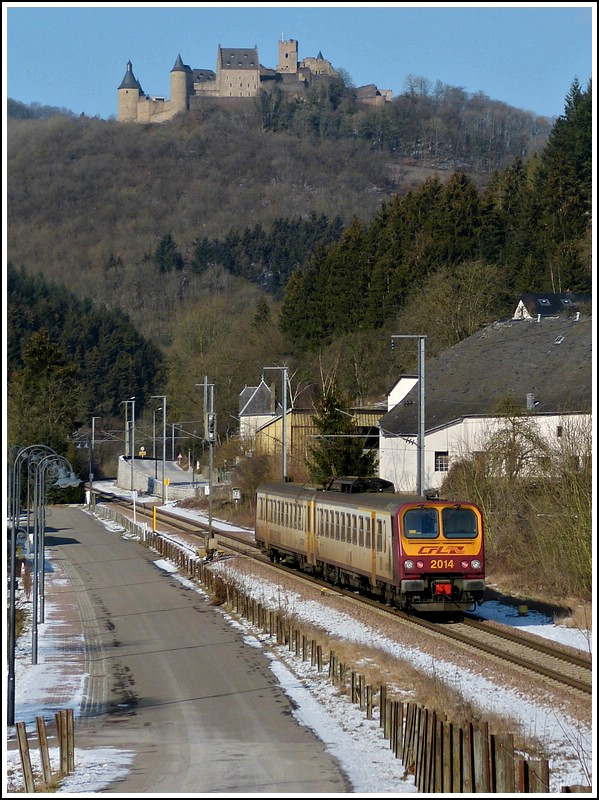 Die Burg Bourscheid thront hoch ber dem Geschehen unten im Sauertal, als der Triebzug Z 2014 als leicht versptete RB 3210 nach Wiltz am 10.02.2012 durch Michelau braust. (Jeanny)