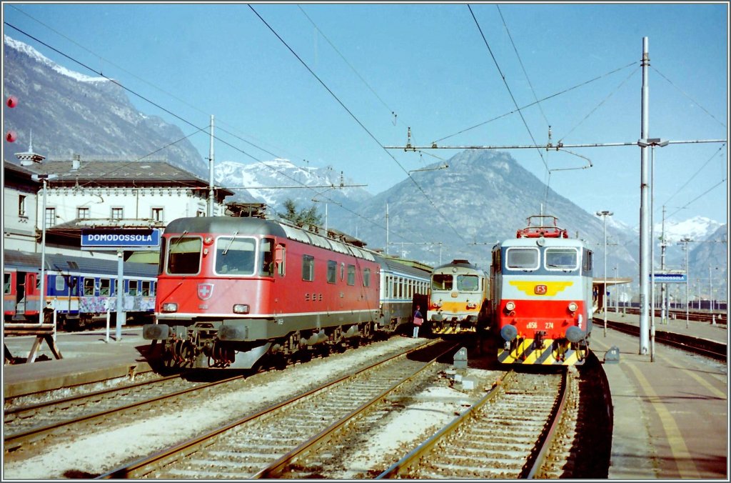 Die SBB Re 6/6 11129 ist mit dem EC  Monteverdi  in Domodossola eingetroffen und wartet nun abgebgelt im Geleichstromsteil auf die italienische Ablsung. 
gescanntes Negativ vom 7. Mrz 1998
