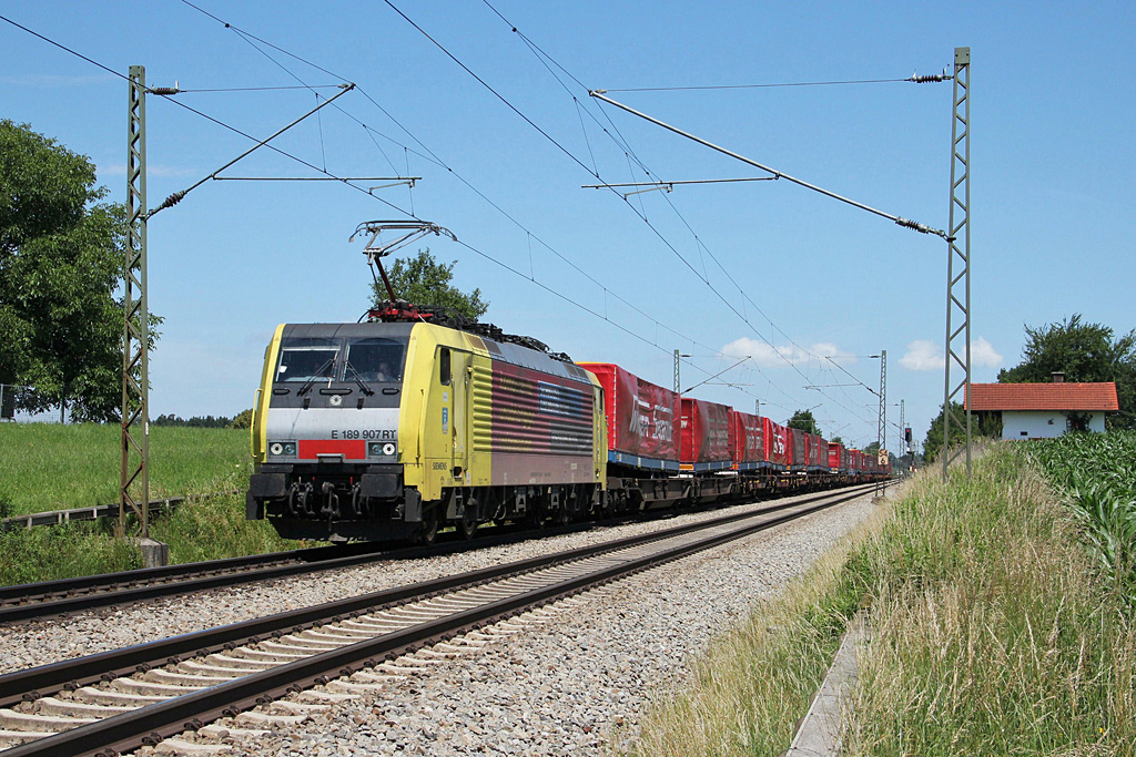 Dispolok 189 907 mit KLV-Zug bei strahlendem Sonnenschein bei Hilperting zwischen Mnchen und Rosenheim am 22.6.2011. Hoffentlich erhlt uns MRCE das gelb-siberne Farbkleid aus Dispolokzeiten noch recht lange.