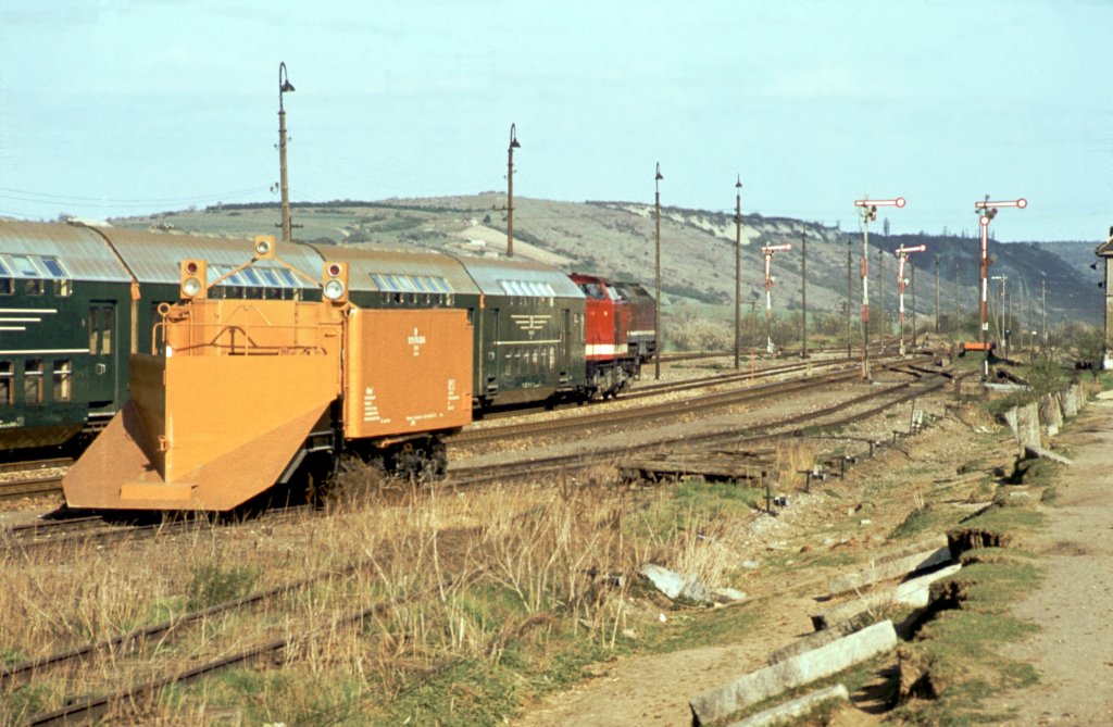 Ein abgestellter Schneepflug und die DR 110 723-4 mit dem Leerzug des P 3573 aus Leuna S�d auf der R�ckfahrt in Richtung Naumburg, im Bf Laucha; 27.04.1982 (Foto: Klaus Pollm�cher)