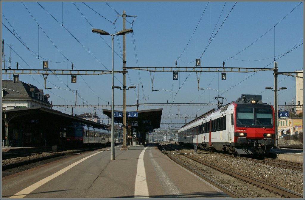 Ein Domino von Yverdon nach Lausanne verlsst Renens VD; im Hintergrund im Schatten beim Empfangsgebude ist der Gegenzug zu erkennen. 
2.Mrz 2012
