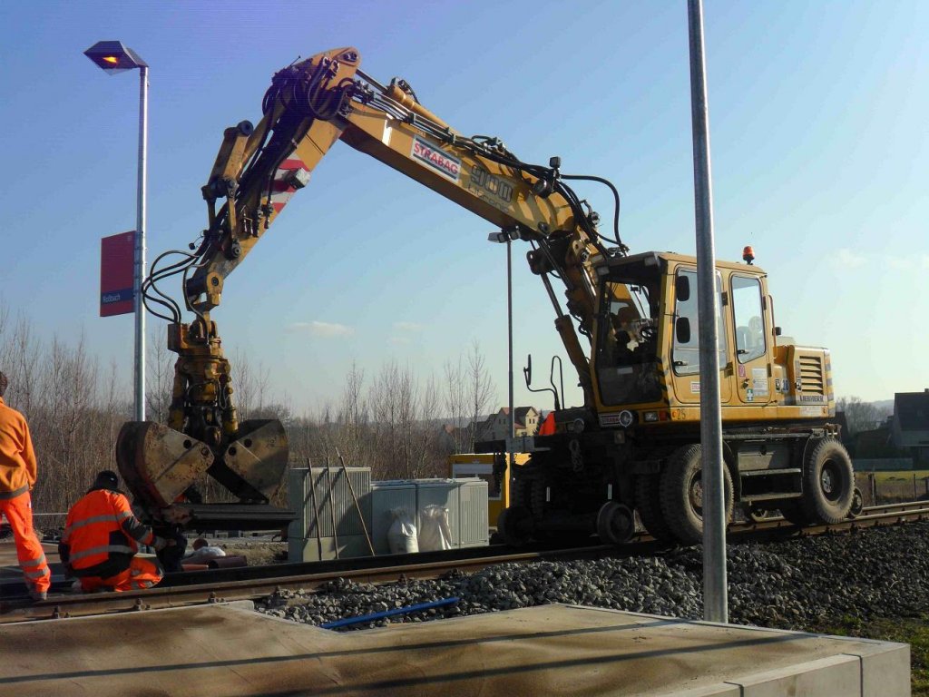 Ein Zweiwegebagger der Firma STRABAG beim Verlegen der Platten f�r den Reisenden�bergang am neuen Hp Ro�bach; 26.01.2012