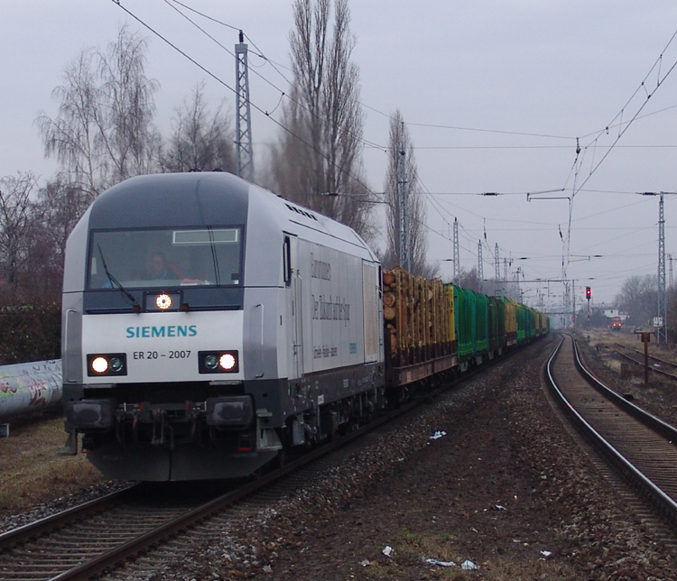 ER20-2007 mit Holzzug von Rostock-Bramow Richtung Stendal-Niedergrne bei der Durchfahrt im S-Bahnhof Rostock-Holbeinplatz.(16.02.2011) 