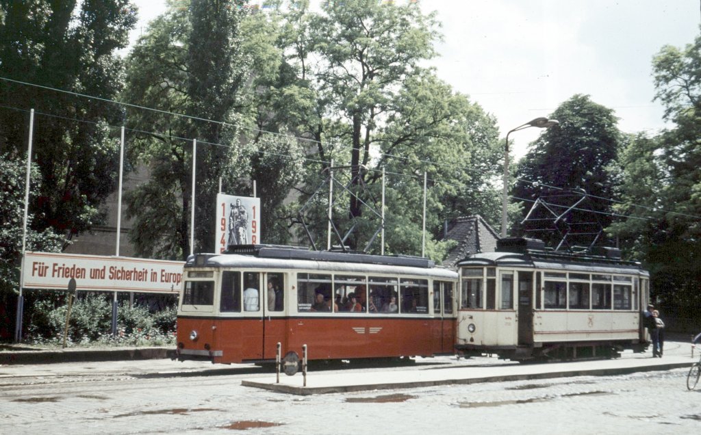 Fr�her konnten Bahnreisende die in Naumburg Hbf ankammen unmittelbar vor dem Bahnhof auf Schienen weiterfahren. Die Stra�enbahn geh�rte damals noch zum t�glichen Stadtbild, auch wenn der  Ring  nicht mehr geschlossen war. Links ist ein Lowa-Tw gerade abgefahren, w�hrend am Lindner-Tw noch Zeit f�r ein  Pl�uschchen  ist. Auch f�r PKW war der Bahnhofsvorplatz noch nicht tabu; 22.06.1980 (Foto: Klaus Pollm�cher) 