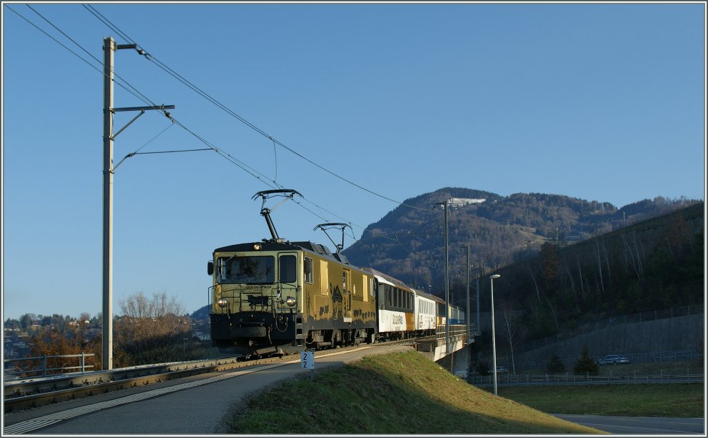 In den ersten Sonnenstrahlen taucht die GDe 4/4  Schokoladen Lok mit eine Regionalzug bei Chtelard (VD) auf.
21. Mrz 2012