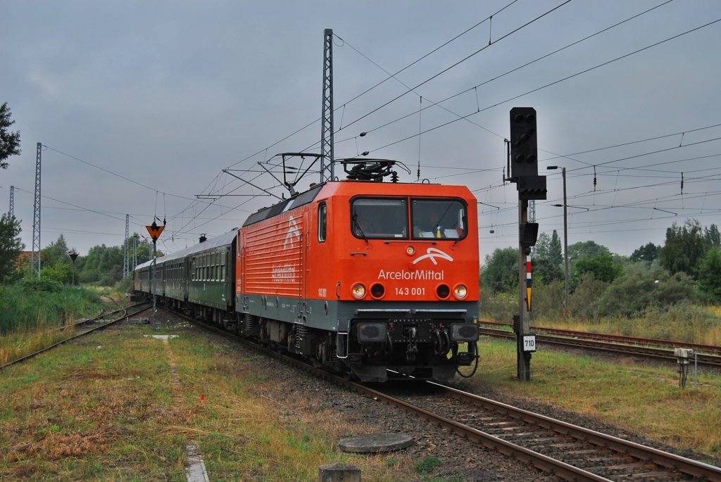 Mit einem Sonderzug aus Cottbus rollt die 143 001 am 07.08.2010 in Haltepunkt Warnemnde Werft.