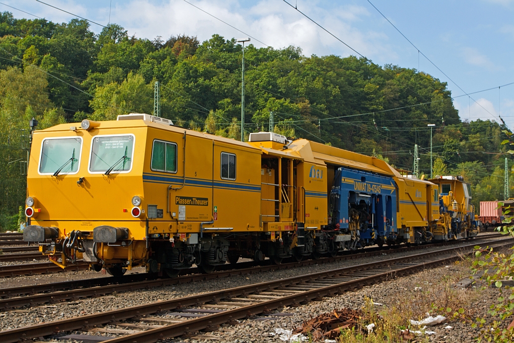 Plasser und Theurer Universalstopfmaschine (Nivellier-, Hebe-, Richt- und Stopfmaschinen) Unimat 09-475/4S (Schweres Nebenfahrzeug Nr. 99 80 9424 001-2) der DGU - Deutsche Gleisbau Union (Koblenz), abgestellt am 22.09.2012 in Betzdorf/Sieg. Sie ist eine kombinierte Gleis- u. Weichenstopfmaschine und wurde 2011 unter der Fabriknummer 1358 gebaut, das Eigengewichtbetrgt 122,6 t, die Hchstgeschwindigkeit bei Eigenfahrt betrgt 100 km/h,  die zugelassene Streckenklasse ist D 4. Dahinter eine Schotterplaniermaschine SSP 110 SW .