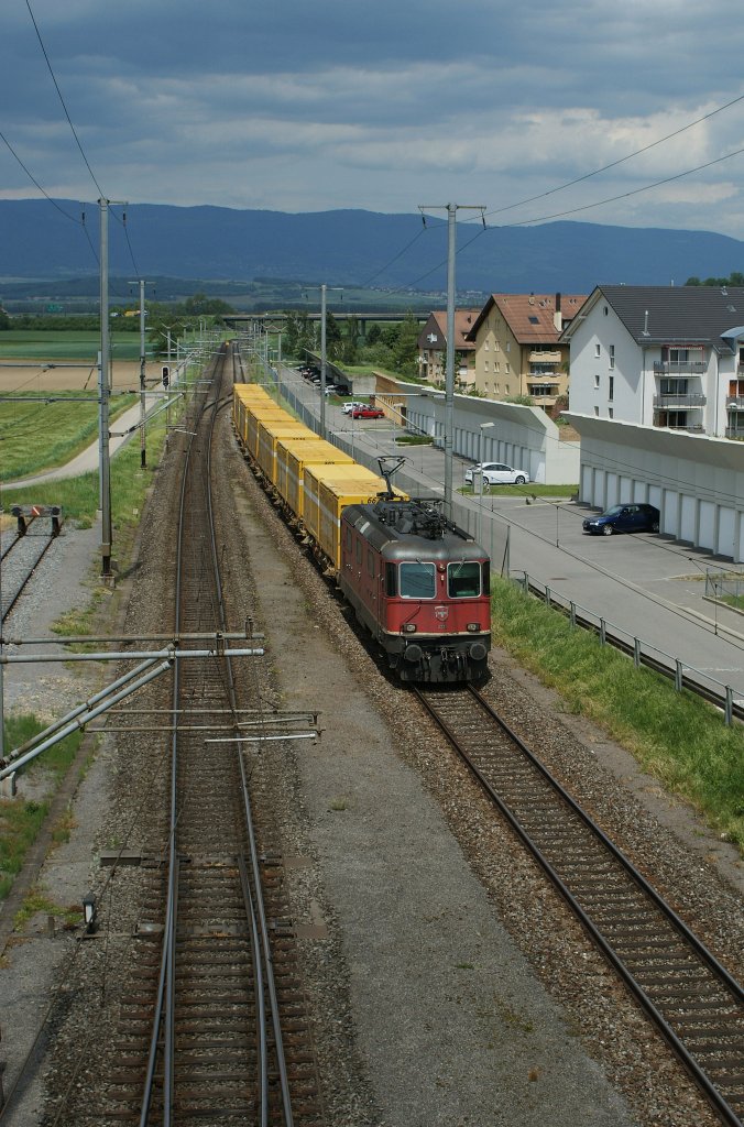 Re 4/4 II mit einem Postzug erreicht Chavornay am 26. Mai 2010