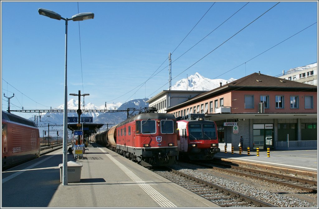 Sion mit einfahrendem IR nach Genve, durchfahrendem Gterzug Richtung Brig und wartendem Domino nach Brig am 5. Mrz 2011.













05. h  e