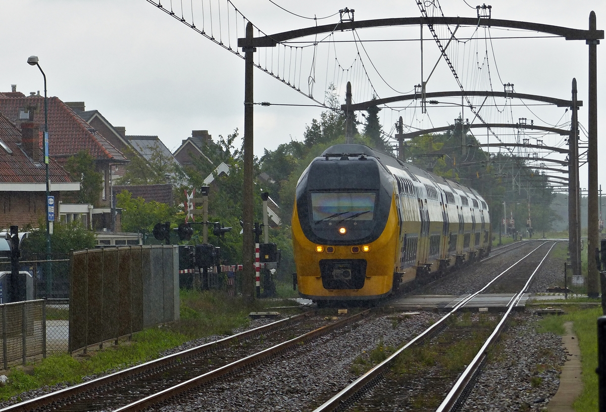 . Im strmenden Regen braust ein sechsteiliger NS VIRM (Verlengd interregiomaterieel) unter den schnen alten Fahrleitungsmasten ohne Halt durch den Bahnhof von Zevenbergen. Er fhrt als IC Lelystad - Amsterdam Centraal - Roosendaal - Vlissingen auf der Bahnstrecke N 12 Antwerpen - Lage Zwaluwe in der niederlndischen Provinz Noord-Brabant. 04.09.2015 (Jeanny)