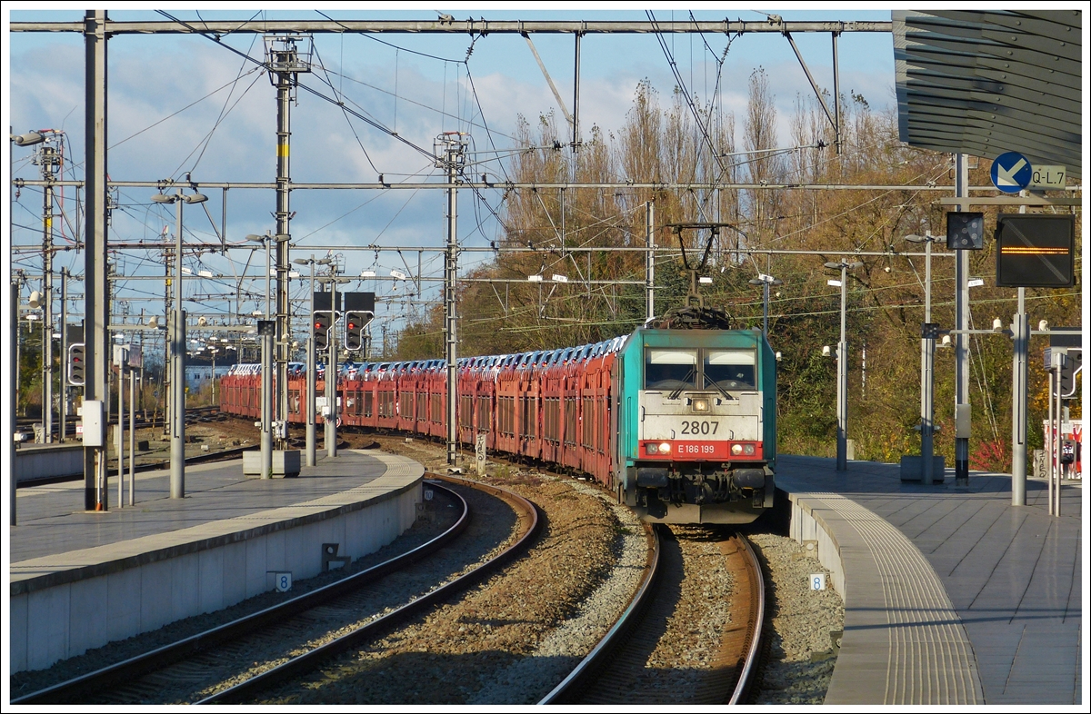 . Leider keine Class 66, sondern  nur  eine Traxx habe ich fotografiert. Am 23.11.2013 zieht die Traxx HLE 2807 einen langen Autozug durch den schnen Bahnhof von Brgge (Bruges/Brugge). (Hans)