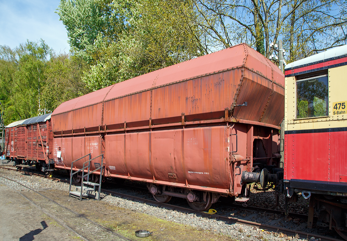 
00t 24 DR Selbstentladewagen 2233 Oldenburg, spter DB 20 80 676 0139-2 der Gattung Fad 150, am 30.04.2017 im Eisenbahnmuseum Bochum-Dahlhausen.
Eine Wagengattung die bis Mitte der 1960er Jahre, durch den Erzbergbau und die Eisenverhttung, auch das Bild im Hellertal geprgt hatte. Daher besa auch der Bahnhof Herdorf ber 10 Gleise (DB), plus die Gleise der Friedrichshtte und der Freien Grunder Eisenbahn.

Die fortschreitende Industrialisierung erforderte den Transport immer grerer Mengen von Massengtern, zum Teil auch ber grere Entfernungen. Beispielhaft seien die Kohletransporte aus Schlesien oder dem Ruhrgebiet. Sowie die Erztransporte von den Nordseehfen, aber auch den deutschen Erzrevieren wie dem Siegerlnder Erzrevier oder dem Salzgitterrevier zu den Industriebetrieben. Die erforderlichen Massengter zur Stahlerzeugung, namentlich Kohle, Koks, Kalk und Erz wurden zunehmend in Ganzzgen transportiert, d.h. alle Gterwagen eines Zuges waren mit dem gleichen Ladegut beladen und fuhren meist zu einem Zielort. Da die blichen offenen Gterwagen nur 15 bis 20 Tonnen Fracht transportieren konnten, waren hufige Fahrten notwendig, wozu eine entsprechende Anzahl Wagen und natrlich auch Lokomotiven mit entsprechendem Personalaufwand notwendig waren.

Der kontinuierliche Ausbau der Eisenbahnstrecken fr schwerere Fahrzeuge ebnete den Weg zur Entwicklung der Groraumgterwagen. Die Selbstentladetechnik ermglichte ein mechanisiertes Be- und Entladen der Wagen unter Ausnutzung der natrlichen Schwerkraft. Ebenso waren fr die gleiche Transportleistung weniger Wagen, weniger Lokomotiven und somit auch weniger Personal- und Reparaturaufwand erforderlich. Ab Mitte der 1920er Jahre wurden die ersten Selbstentlade-Groraumgterwagen der Gattung 00t(n) durch die Deutsche Reichsbahn beschafft. Bei einer Lnge von 12 m konnte der hier gezeigte Wagen Oldenburg 2 233 rund 56 t Ladegut transportieren. Dazu waren frher 3 bis 4 normale offene Gterwagen notwendig, die zusammen eine Lnge von 30 bis 40 Metern erreichten!

Das hohe Ladegewicht erforderte vier Radstze, die mit bis zu 20 t belastet wurden. Sie wurden bei diesem ersten Groraumwagentyp aber noch nicht wie heute blich in Drehgestellen, sondern paarweise als freie Lenkachsen eingebaut. Die Achsen haben in ihren durch eiserne Streben versteiften Achsfhrungen Seiten- und Lngsspiel und ermglichen ein verschleivermindertes Durchfahren von Kurven, da sich die Radstze radial einstellen knnen. Ein weiterer Fortschritt war die Anwendung einer automatischen Scharfenbergkupplung. So konnte die Zugbildung vereinfacht werden, da mit dieser Bauart das Kuppeln selbstttig erfolgte. Mit einer Notkupplung kann mit normalen Kupplungen gekuppelt werden. 
TECHNISCHE DATEN:
Selbstentladewagen Deutsche Reichsbahn
Bauart: 00t 24 
Baujahr: 1930
Hersteller: O&K, Berlin-Spandau
Lnge ber Puffer: 12.000 mm
Eigengewicht: 22,3 t
max. Ladegewicht: 56.0 t
max. Gesamtgewicht: 78,3 t
Ladevolumen: 92 m
Hchstgeschwindigkeit: 65 km/h
Fahrgestell und Wagenaufbau aus Stahl (Bleche aus St 52), genietet
