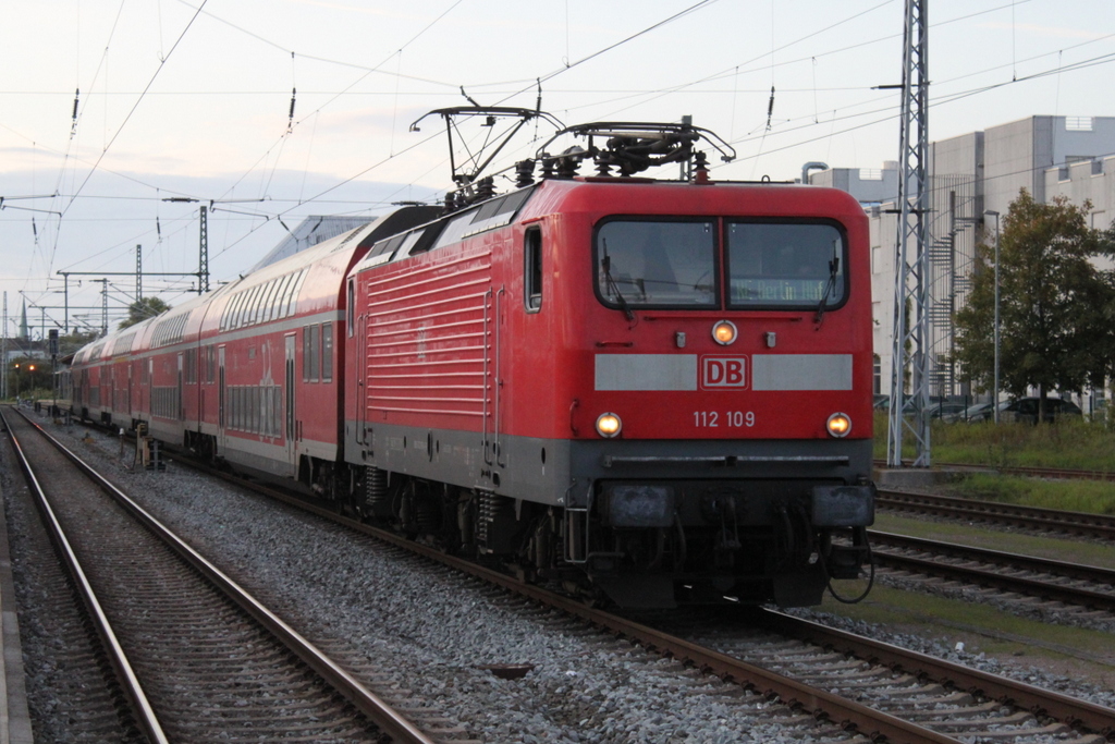 112 109 mit RE 18491 von Rostock Hbf nach Berlin Hbf(tief)bei der Ausfahrt am Abend des 28.09.2019 im Rostocker Hbf.