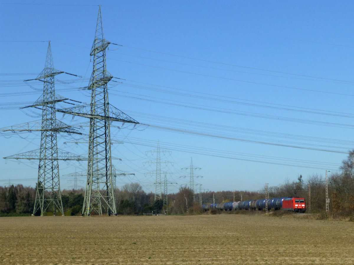 185 318 vor der Kulisse mehrerer mächtiger Hochspannungsmasten im Rheinland, 27.2.19.