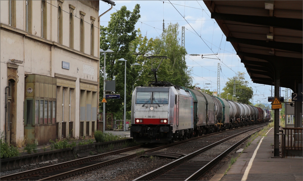 186 451 mit gemischtem Güterzug in Richtung Süden passiert das nicht mehr im besten Zustand befindliche Bahnhofsgebäude von Bad Hönningen. Man kann nur hoffen, dass die Renovierungsarbeiten im Inneren weitergehen und auch auf das Äußere übergehen werden. (25.07.2020)