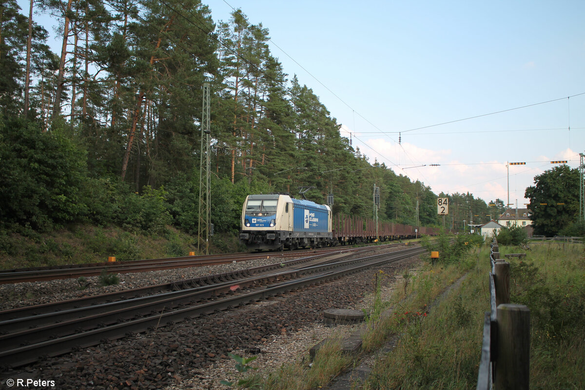 187 323 mit einem leeren Holzzug bei der Durchfahrt in Ochenbruck. 10.09.23