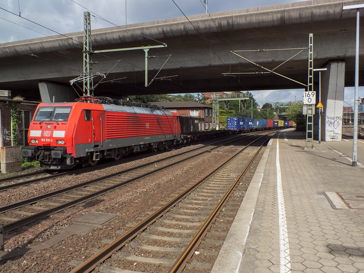 189 010 unterquert mit einem vermutlich aus dem Hafen kommenden, recht gut ausgelasteten Zug des Kombinierten Verkehrs die Harburger Umgehungsautobahn A253, die keinerlei Kontakt zu restlichen Autobahnnetz hat. Einige Stunden später traf ich denselben Zug übrigens in Stendal wieder.