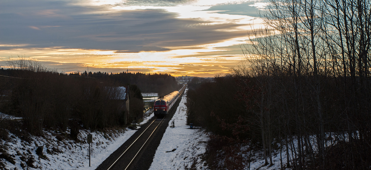 218 423-2 war am frühen Abend des 05.01.15 mit ihrem Bn-Wagenzug nach Mühldorf in Wimpasing, Nähe Ottenhofen, unterwegs. Im Hintergrund erkennt man die Kleinstadt Markt Schwaben.