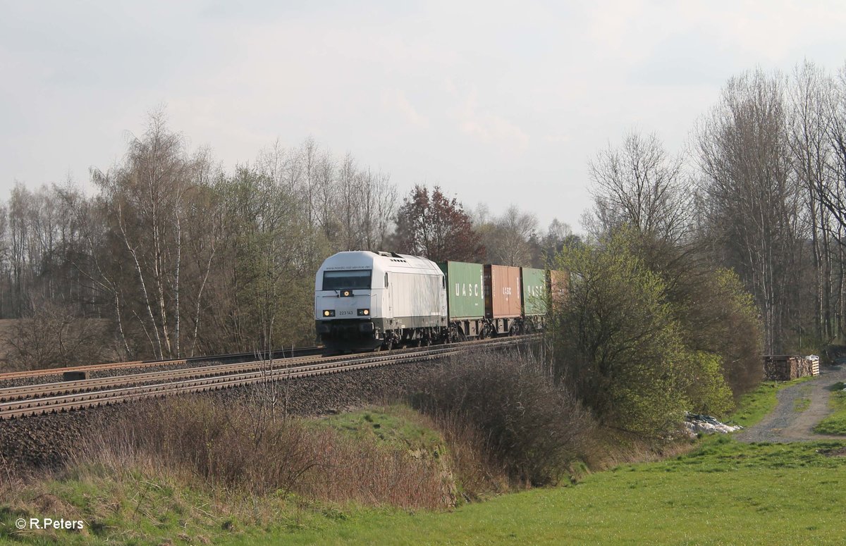 223 143 rollt langsam mit dem Wiesau Containerzug nach Hamburg kurz hinter Wiesau und erreicht gleich den BÜ Schönfeld. 12.04.16