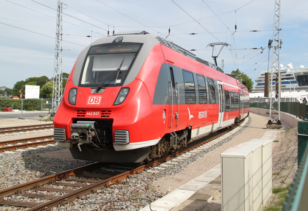 442 837 als S1(33490)von Rostock Hbf nach Warnemnde bei der Einfahrt in Warnemnde im Hintergrund lag das Kreuzfahrt-Schiff Aidamar.16.07.2016