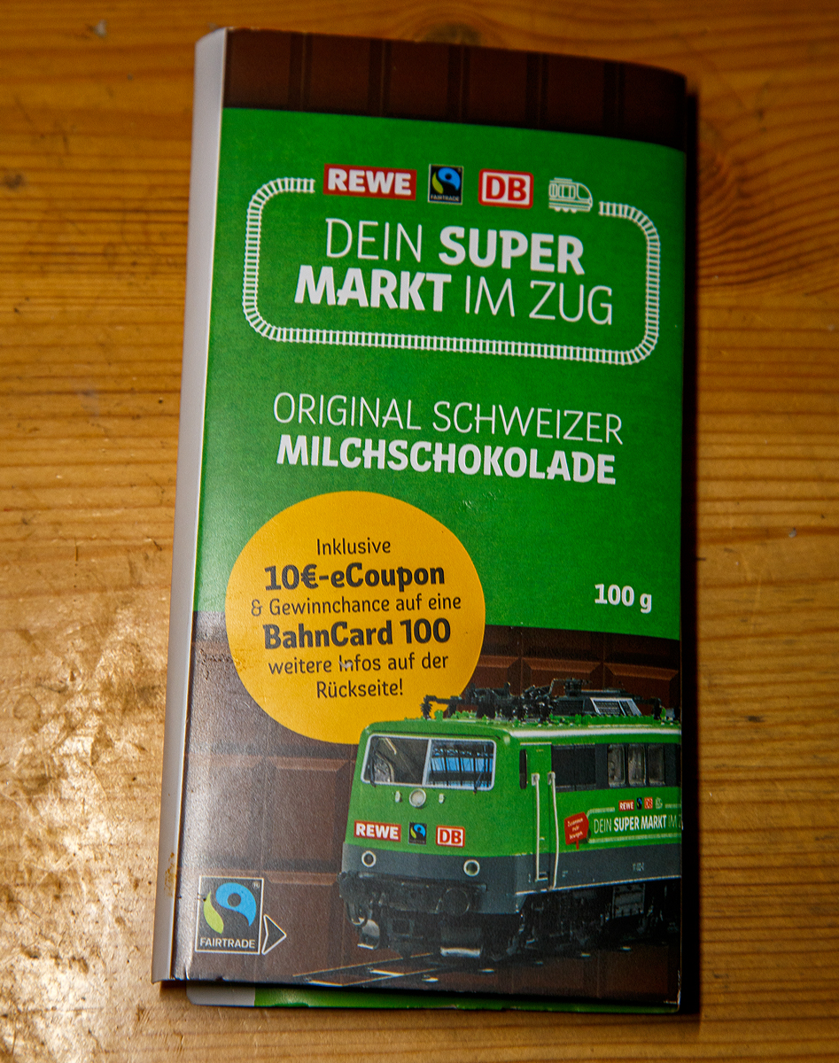 Als besondere Aktion, konnte man im dem im REWE - Supermarkt-Zug (hier am 12.11.2021 im Bahnhof Gießen) auch eine Fairtrade-Aktionsschokolade (Schweizerschokolade) kaufen: Fair naschen, sparen & frei fahren!