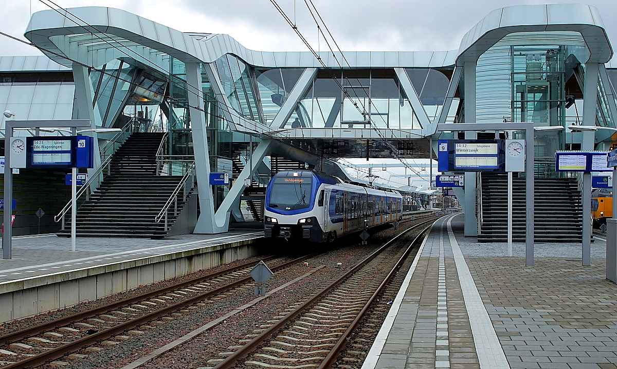 Am 02.01.2018 verlässt ein vierteiliger Flirt 3 der NS Arnhem Centraal als Sprinter (Regionalzug) in Richtung Ede-Wageningen. Der neue Bahnhof mit der imponierenden Fußgängerüberführung wurde 2015 eröffnet.