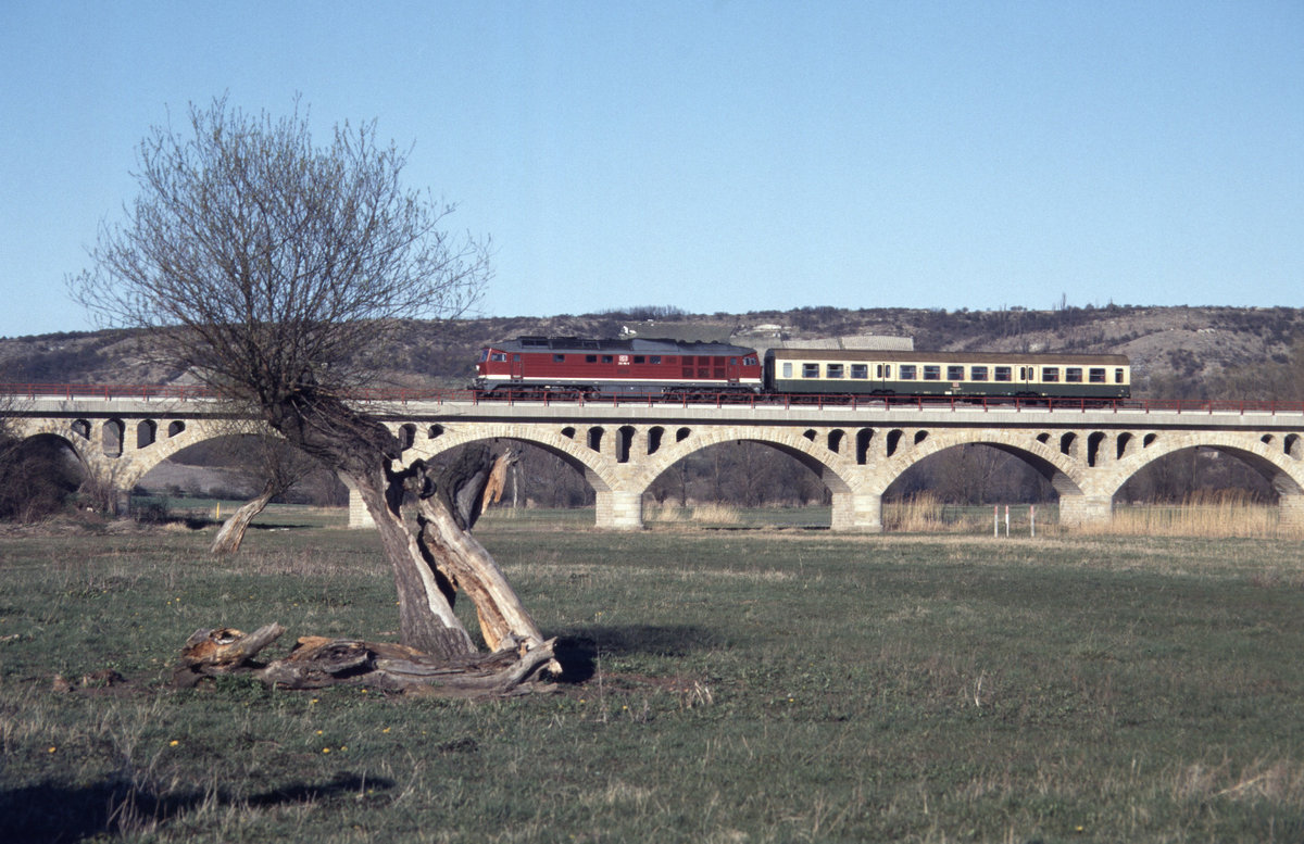 Am 07.04.1997 war die DB 232 156-0 mit einem Bmh-Wagen als RB 15628 von Naumburg Hbf auf dem Unstruthochwasserviadukt bei Kirchscheidungen unterwegs nach Nebra. (Foto: Klaus Philippi)