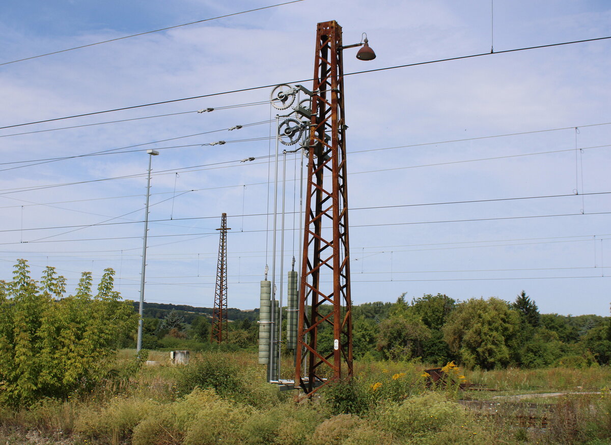 Am Bahnsteig 2 in Naumburg (S) Hbf hat dieser alte Fahrleitungsmast mit einem alten Beleuchtungskandelaber alle Modernisierungsarbeiten überlebt; 07.08.2025.