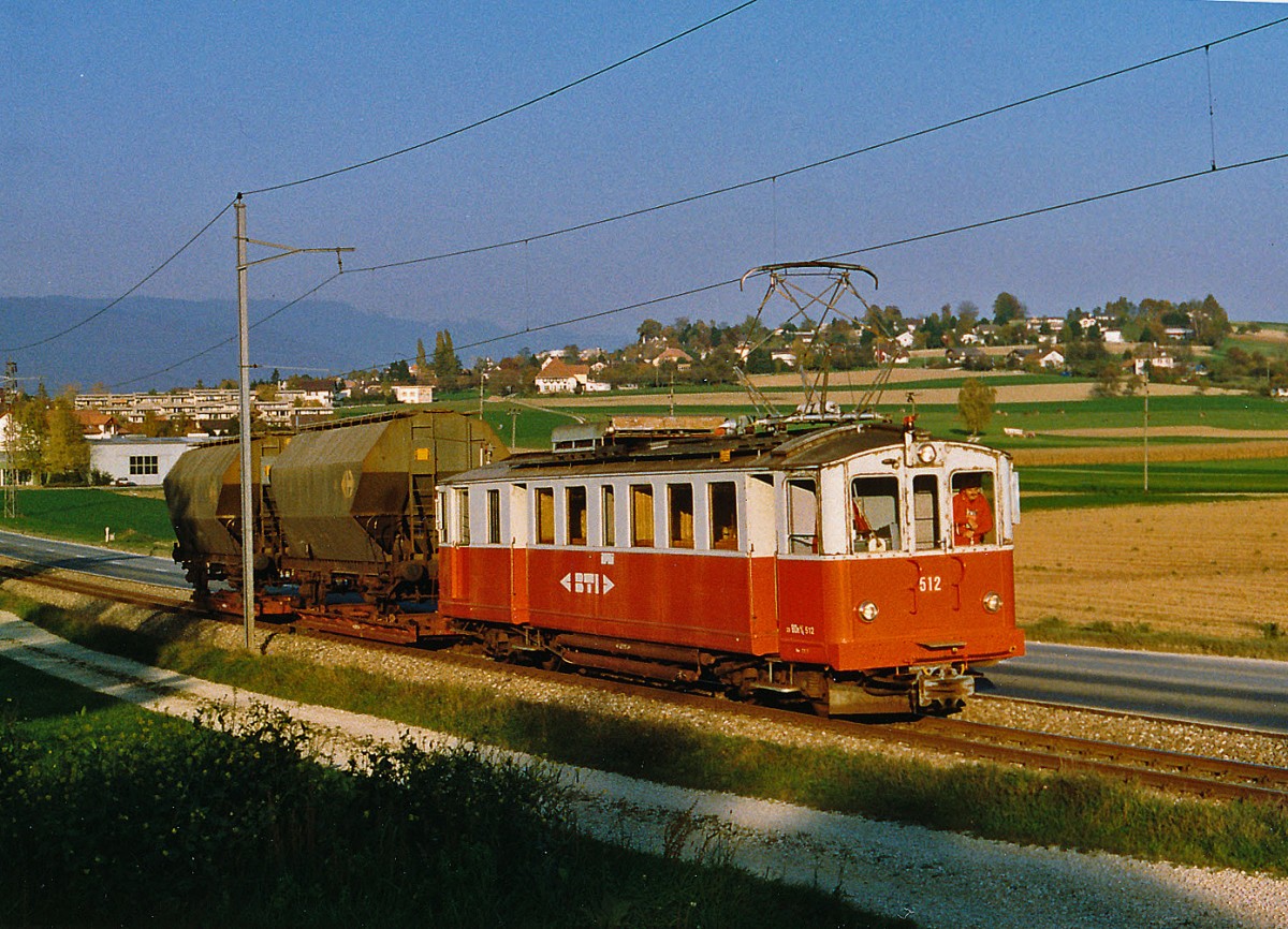ASM/BTI: Als noch in Lscherz Getreide vom Lastwagen auf die normalspurigen Silowagen verladen wurde, verkehrten whrend der Getreideernte der Monate Juli und August mehrmals Rollschemelzge zwischen Biel und Siselen, wo die Zge umfahren werden mussten, um das Anschlusgeleise Lscherz mit nur einer Weiche rckwrts zu bedienen. Leider wurde der Rollschemelverkehr im Dezember 2001 nach 84 Jahren eingestellt. Die Rollschemelanlage beim SBB-Bahnhof Biel musste wegen dem Bau der EXPO'02-Arteplage Biel entfernt werden. Bei Sutz wurde der BDe 4/4 12, (1916,ehemals SZB) im August 1997 im Bild festgehalten, als er zwei leere Silowagen nach Lscherz brachte. 
Foto: Walter Ruetsch
