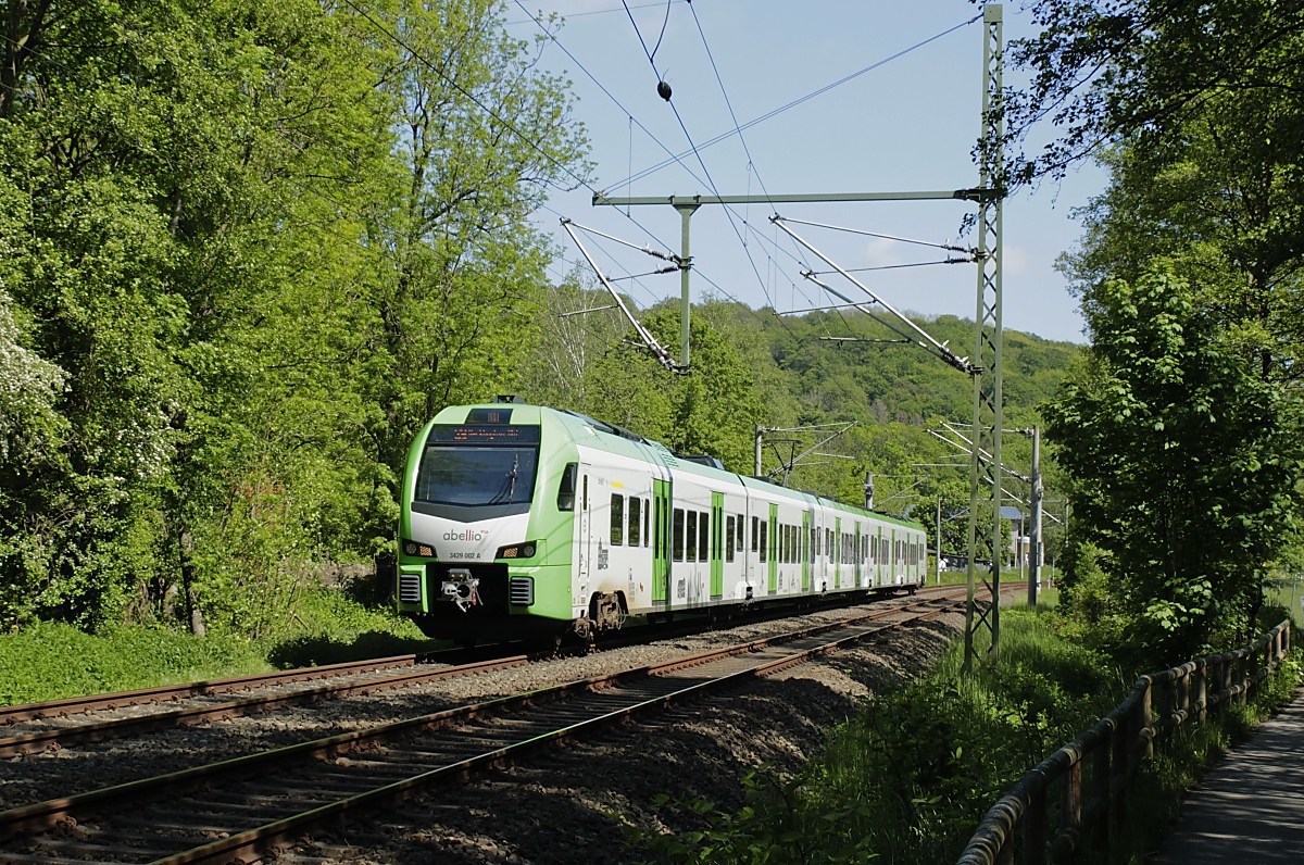 Auf der ältesten noch in Betrieb befindlichen Bahnstrecke Deutschlands ist der Abellio-Flirt 3 3429 002 als S 9 (Wuppertal Hbf. - Essen Hbf.) zwischen Nierenhof und Essen-Kupferdreh am 29.05.2021 unterwegs. Die Bahn wurde 1831 von der Deilthaler Eisenbahn (später Prinz-Wilhelm-Eisenbahn) als Pferdebahn mit 820 mm Spurweite von (Essen-)Byfang nach Nierenhof eröffnet, 1844 umgespurt und bis (Wuppertal-)Vohwinkel verlängert. Leider ist auch diese Bahnlinie vom Hochwasser in der vorletzten Woche betroffen und derzeit gesperrt. Durch die Überflutung ist das Schotterbett mit Schlamm durchsetzt und an anderen Stellen weggespült worden. Weiterhin wurden Leitungen und Kanäle sowie die Schalthäuser an fast allen Bahnübergängen zerstört. Wahrscheinlich dauert es Monate, bis hier wieder Züge fahren werden.