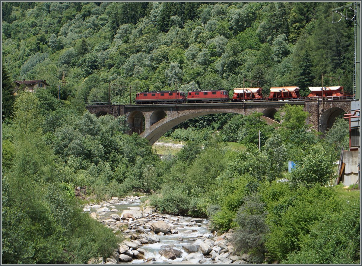 Auf der Gotthard Südrampe kurz nach Faido ziehen eine Re 10/10 einen Kieswagenzug bergwärst. Bei genauerem Hinschauen, bemerkt man den zweiteiligen Kasten der SBB Re 6/6. 

23. Juni 2015