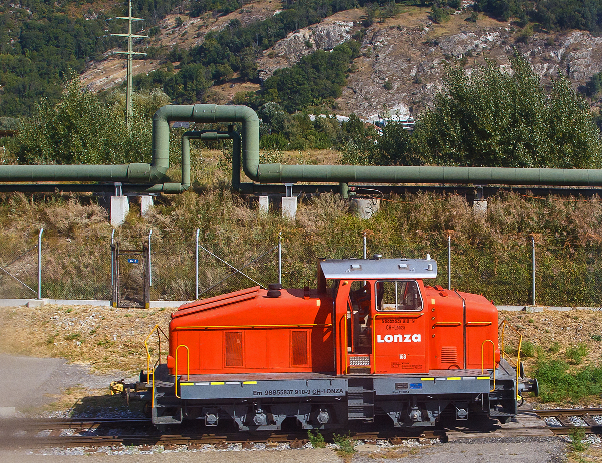 Aus dem Zug heraus, die Em 3/3 163  Rene  (98 85 5837 910-9 CH-LONZA) eine Henschel DHG 500 C der Lonza  AG (Visp), steht am 09.09.2021 in Visp.

Die Henschel  DHG 500 C wurde 1968 von Henschel in Kassel unter Fabriknummer  31239  gebaut und war erst als Mietlok im Einsatz. Im Jahr 1971 verkaufte sie dann Henschel an die Lonza AG in die Schweiz.
2014 wurde die Lok von der LSB Lok Service Balmer AG in Hinwil komplett neu revidiert und remotorisiert.

Die Henschel DHG 500 C ist eine dieselhydraulische Lokomotive, die von den Henschel-Werken gebaut wurde. Sie war vor allem fr den Einsatz im schweren Werksdienst vorgesehen. Die Lok gehrt zur ab 1962/63 angebotenen sogenannten vierten Generation der Henschel-Loks, der ersten Generation mit Gelenkwellenantrieb. Die Aufbauten wurden dabei ohne groe nderungen von der vorigen Generation bernommen.  Zur besseren Bogenlufigkeit war die mittlere Achse seitenverschiebbar gelagert. 

Von den Henschel DHG 500 C wurde zwischen 1963 und 1976 insgesamt  62 Exemplaren gebaut. Die Loks gingen vornehmlich an Bergbaugesellschaften und Stahlproduzenten sowie Chemieunternehmen. So erwarb die Rheinelbe Bergbau AG in Gelsenkirchen elf Loks und die Hibernia AG, Zechenbahn- und Hafenbetriebe Ruhr-Mitte in Gladbeck neun Loks vom Typ DHG 500 C. Die meisten Lokomotiven wiesen bei Auslieferung den Henschel-Standardanstrich in Blau mit zwei horizontalen Zierstreifen an den Vorbauten auf. Die durch Zusammenschluss entstandene Ruhrkohle AG hatte zeitweise 31 Lokomotiven dieses Typs im Bestand. 

TECHNISCHE DATEN (nach Umbau):
Spurweite: 	1.435 mm (Normalspur)
Achsformel: C
Lnge ber Puffer:  9.900 mm
Hhe:  4.225 mm
Breite: 3.040 mm
Fester Radstand:  3.700 mm
Kleinster bef. Halbmesser: 	80 m
Dienstgewicht:  60 t
Hchstgeschwindigkeit: 30 km/h / 60 km/h (Schleppfahrt 70 km/h)
Treibraddurchmesser: 	1.000 mm
Motor:  neuer Deutz V6 Motor mit elastischer Vorschaltkupplung. inkl. Partikelfilter (Vollstrombrenner mit aktiver Regeneration), 
der ehemalige Motor war ein Henschel 12V 1416 
Installierte Leistung:  368 kW (500 PS)
Getriebe: 	Voith
Leistungsbertragung:  hydraulisch (ber Gelenkwellen)
