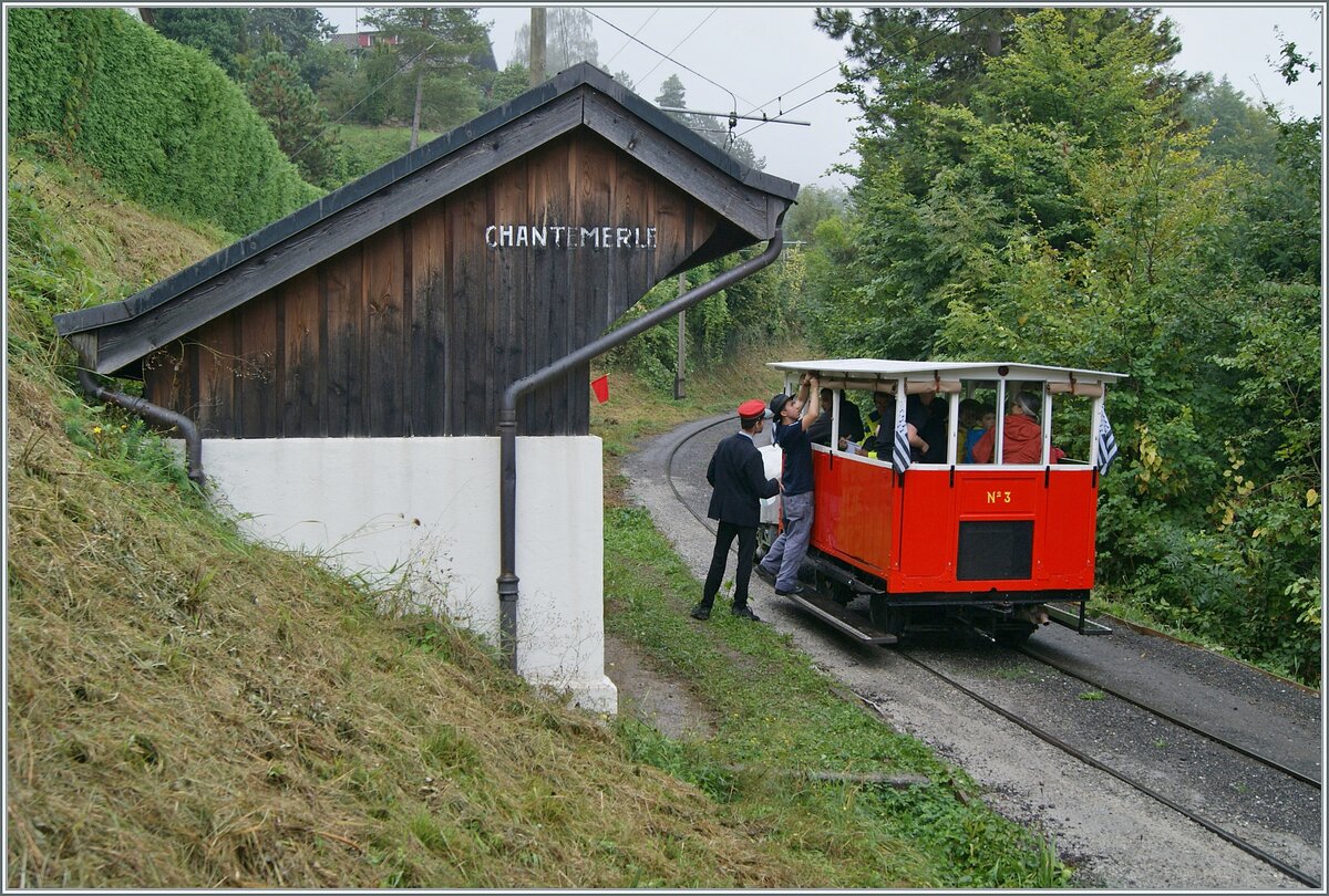 Autour de la voie ferrée / Rund um die eiserne Bahn (Herbstevent 2024) - Nachdem erstaunlich viele Reisende in der kleine Dm 2/2 N° 3  Le Biniou  Platz gefunden haben, ist der Zug praktisch für die Rückfahrt bereit. Es müssen nur noch - nach dem der Regen aufgehört hat - die Storen aufgerollt werden; ein Vorgang welcher der Chef de la Gare interessiert beaufsichtigt. Noch ein kleines, wichtiges Detail: Wenn man genau hinsieht, bemerkt man in der Bildmitte eine rote Flagge, welche als Haltesignal für andere Züge die Fahrt des Dm 2/2 absichert.

8. Sept. 2024