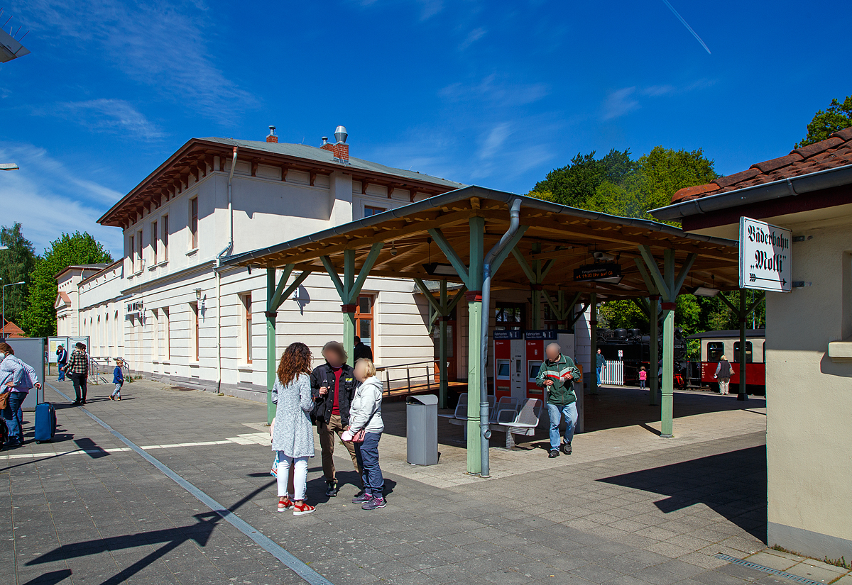 Bahnhof Bad Doberan am 15.05.2022, das Empfangsgebude der normalspurigen DB Bahnstrecke Wismar–Rostock – Tessin (KBS 185). Hinten wartet bereits ein Dampfzug der schmalspurigen (900 mm) Mecklenburgischen Bderbahn Molli, nach Khlungsborn-West. Die Zge werden auch als RB 31 „Bderbahn Molli“ gefhrt, z.Z. (Juni, Juli und August 2022) gilt auch bei der Mecklenburgischen Bderbahn Molli das bundesweite 9-Euro-Ticket!