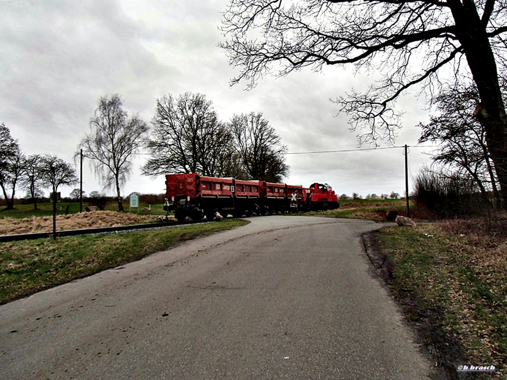 bahnübergang beim glinder bahnhof,261 067 mit 2 schotterwagen der gattung FANS,fuhr grade weg,richtung hamburg,09.02.16