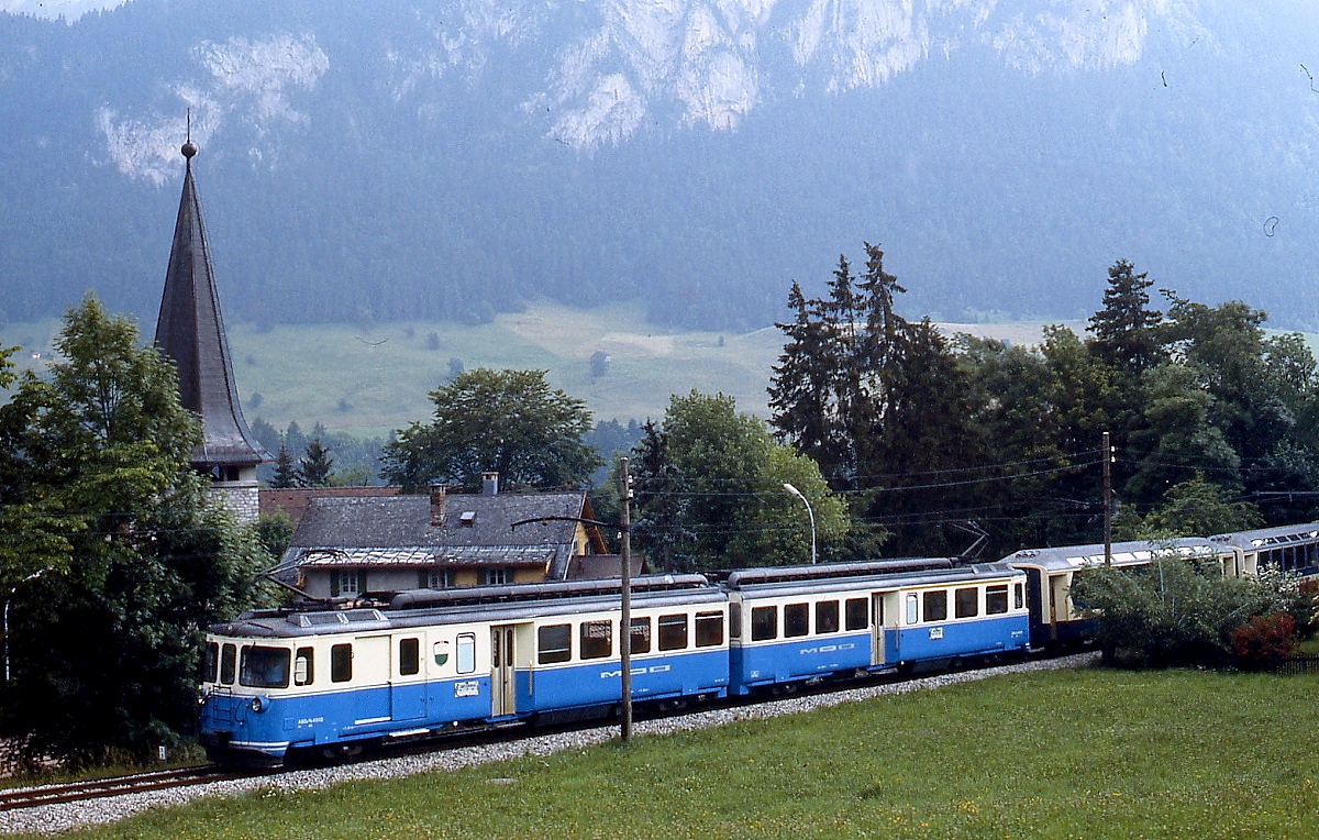 Bei Chateaux d'Oex (?) ist ein ABDe 8/8 der MOB im Juli 1983 unterwegs (Anmerkung: Ich bin mir nicht mehr ganz sicher, ob ich die Aufnahme tatsächlich in Chateaux d'Oex gemacht habe, für eine Hilfe bei der genauen Ortsbestimmung wäre ich daher dankbar)